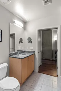 a bathroom with a granite countertop sink a toilet and a mirror