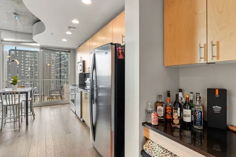 a kitchen with stainless steel appliances granite countertop a refrigerator and a wooden cabinets