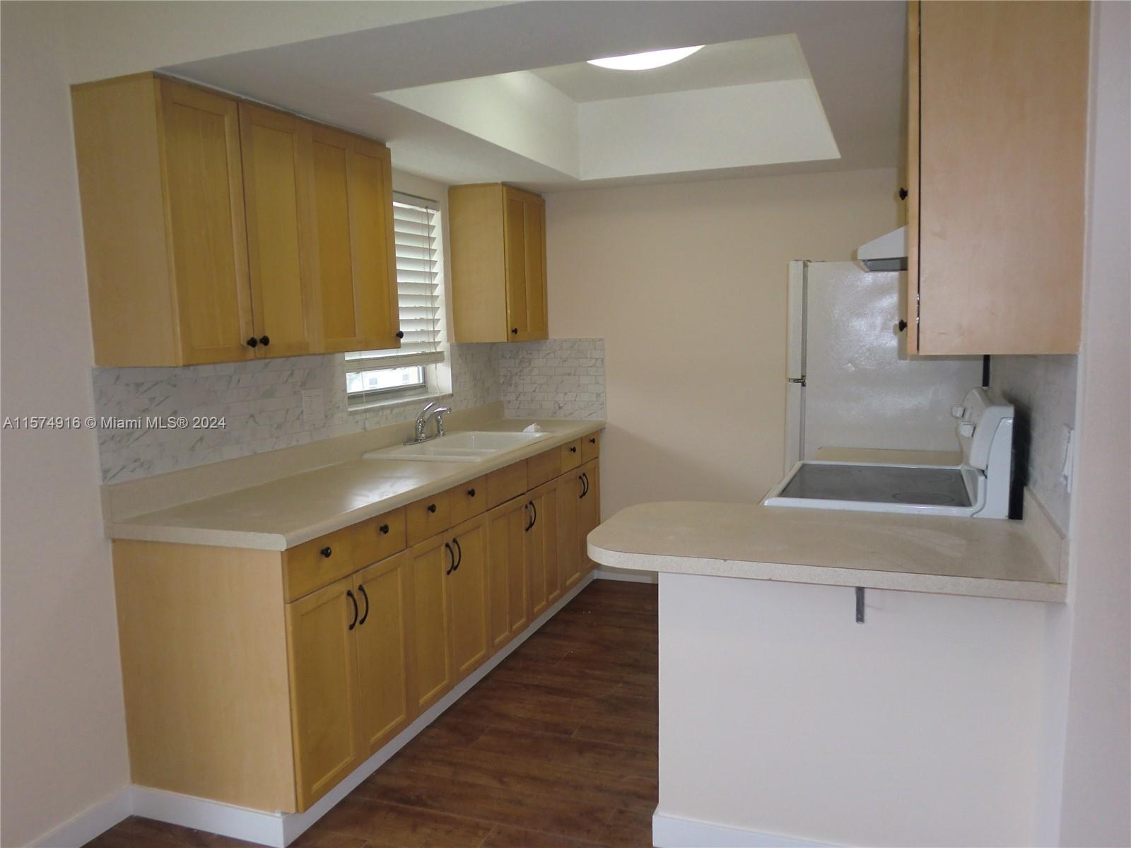 a kitchen with a sink cabinets and a window