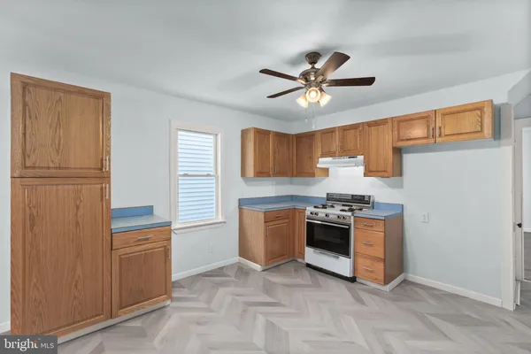 a kitchen with a stove top oven cabinets and a refrigerator