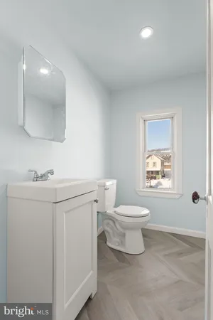 a bathroom with a sink a toilet and mirror