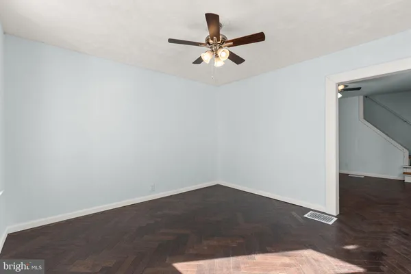 a view of a room with wooden floor and a ceiling fan