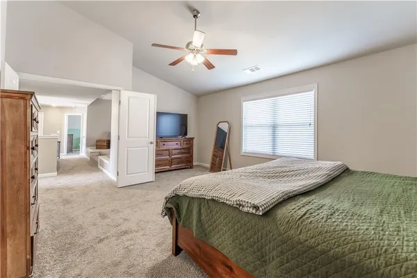 a spacious bedroom with a bed a window and walk in closet