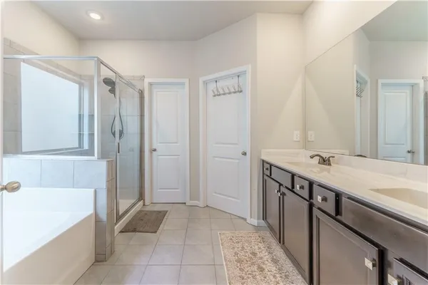 a bathroom with a tub sink and mirror
