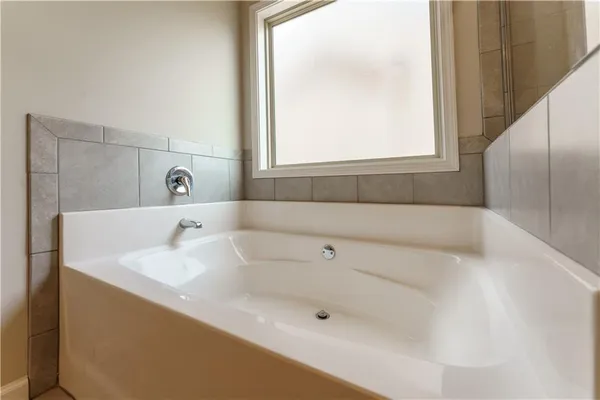 a bathroom with a tub sink and mirror