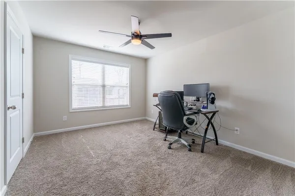 a view of a workspace with furniture and a window