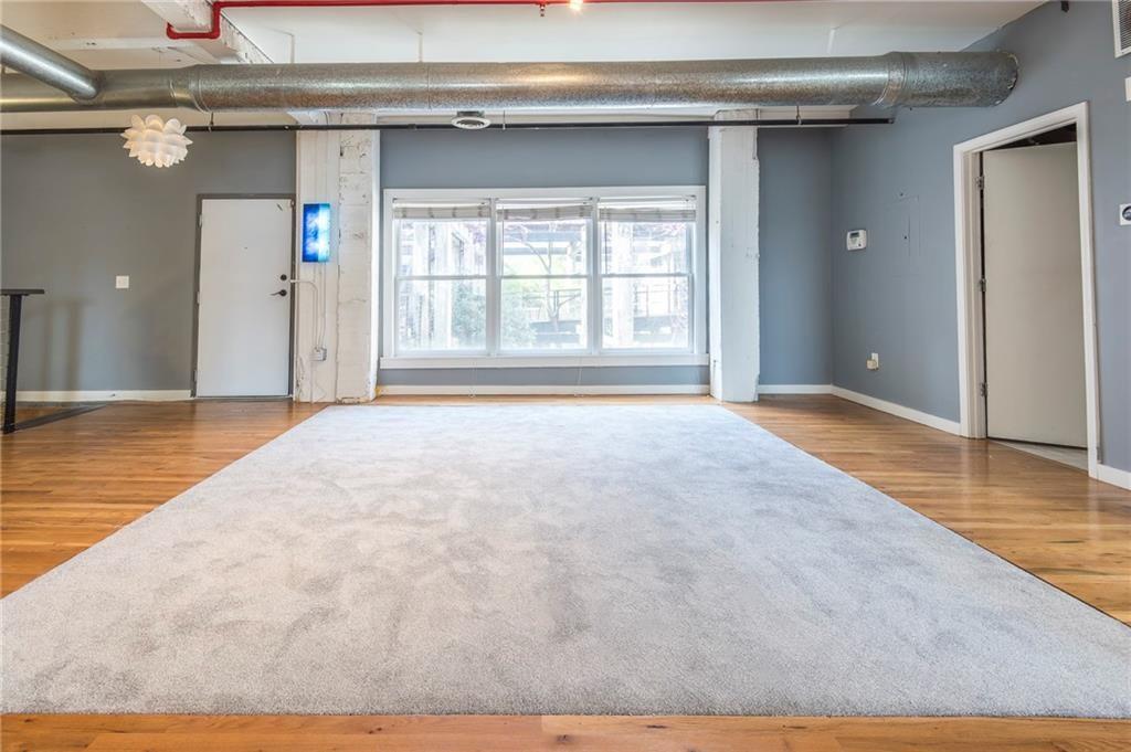 244 Peters Street Southwest, Unit 10 Atlanta, GA 30313 - Photo 11 of 38 a view of an empty room with wooden floor and a window