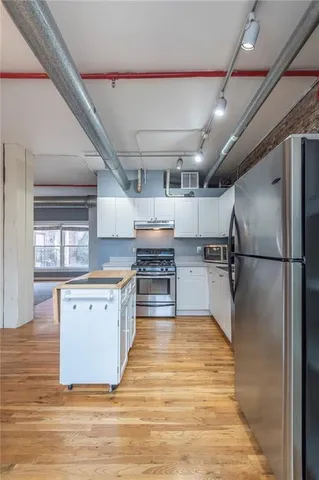 a kitchen with stainless steel appliances granite countertop a refrigerator and a stove