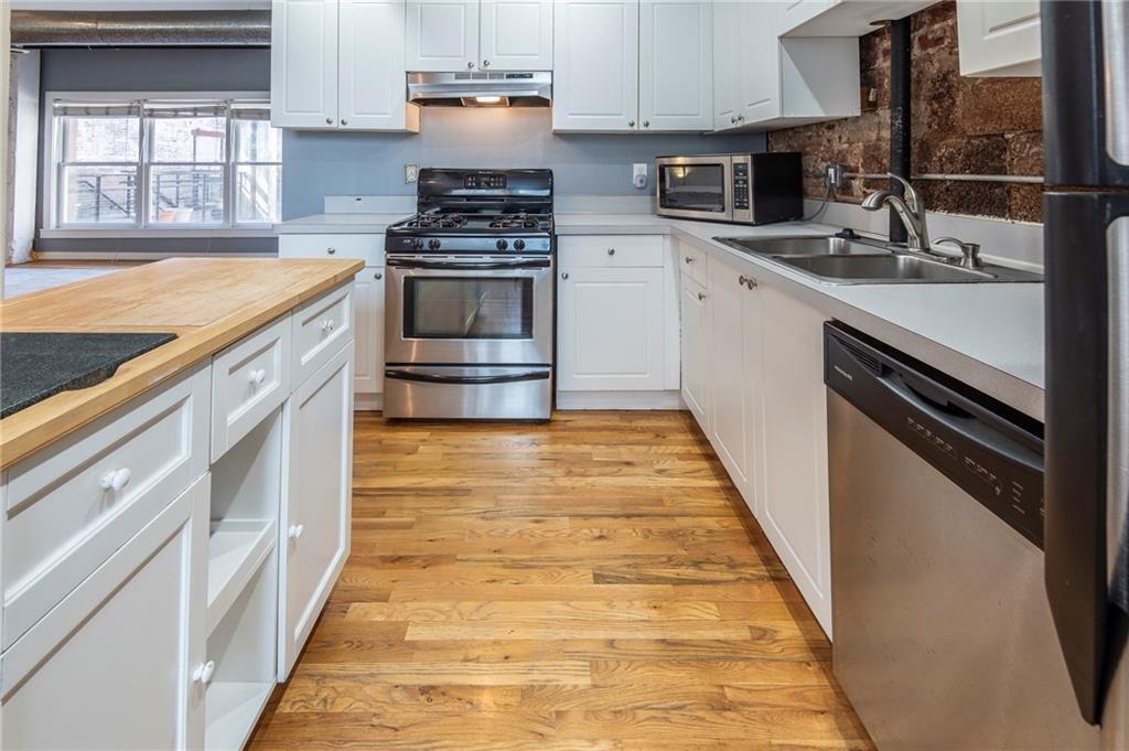 244 Peters Street Southwest, Unit 10 Atlanta, GA 30313 - Photo 14 of 38 a kitchen with a sink stove and cabinets