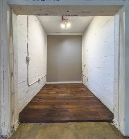 a view of a hallway with wooden floor and closet
