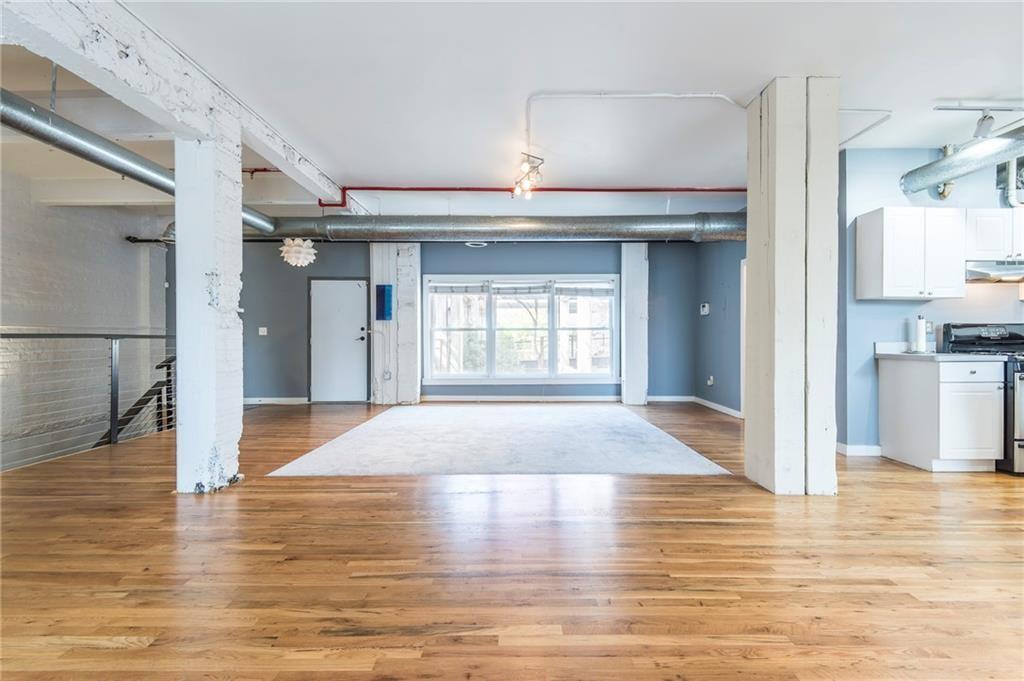 244 Peters Street Southwest, Unit 10 Atlanta, GA 30313 - Photo 8 of 38 a view of a hallway with wooden floor and a kitchen