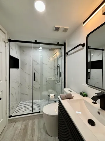 a bathroom with a sink toilet a mirror and shower