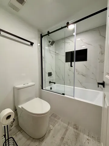 a bathroom with a toilet and a shower