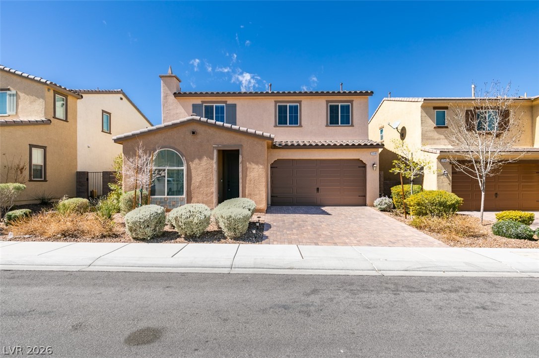 An inviting exterior with a paver driveway, well-maintained landscaping, and a two-car garage awaits.
