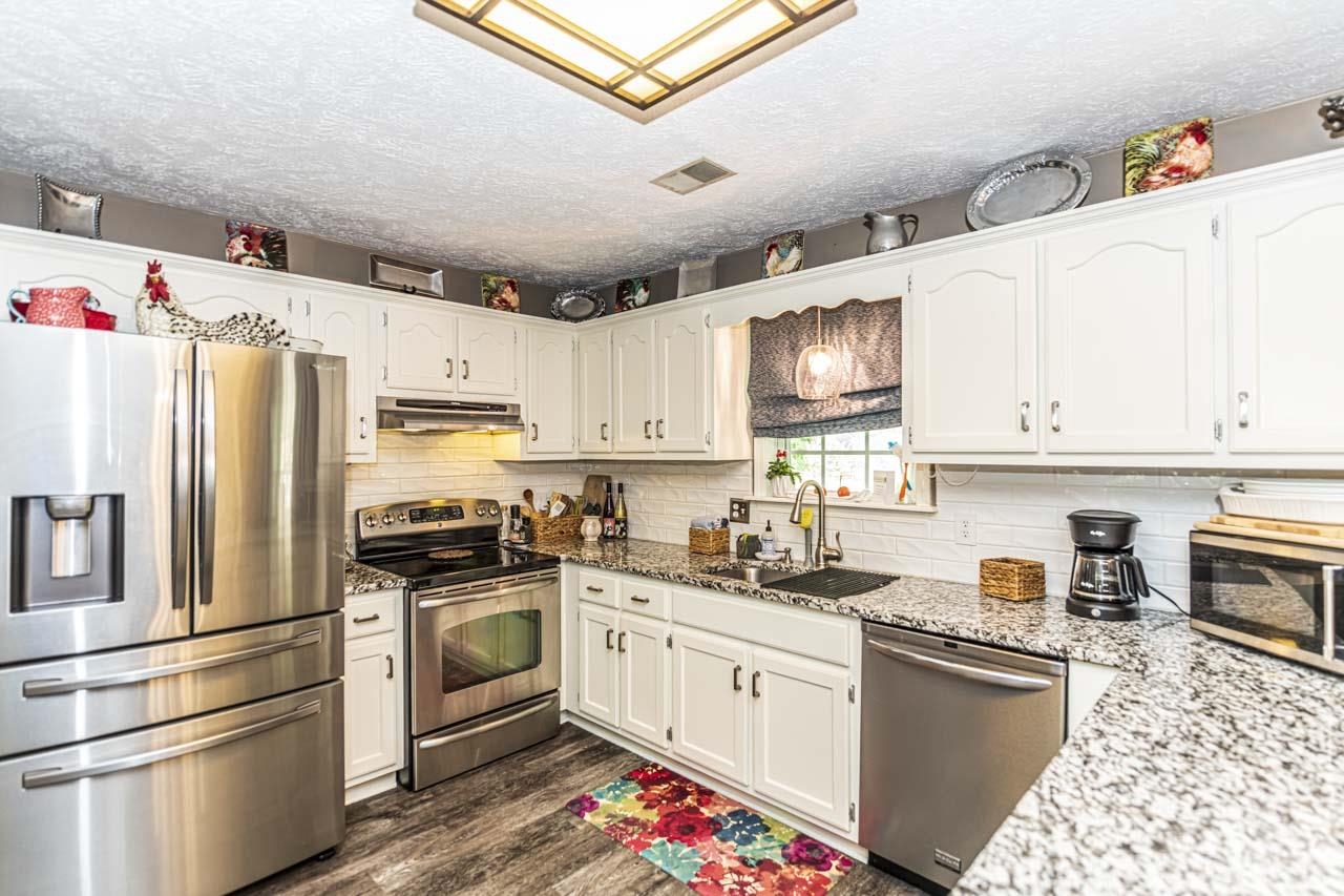 1803 Curve Woodville Road Ripley, TN 38063 - Photo 17 of 23 a kitchen with granite countertop stainless steel appliances cabinets a sink and a counter top space