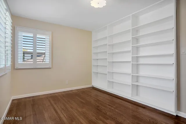 a view of a room with wooden floor and a window