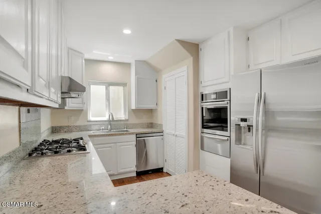a kitchen with stainless steel appliances a refrigerator sink and stove