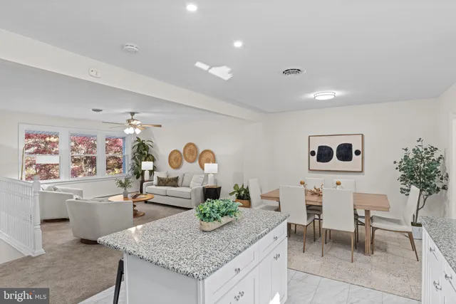 a kitchen with granite countertop white cabinets and window