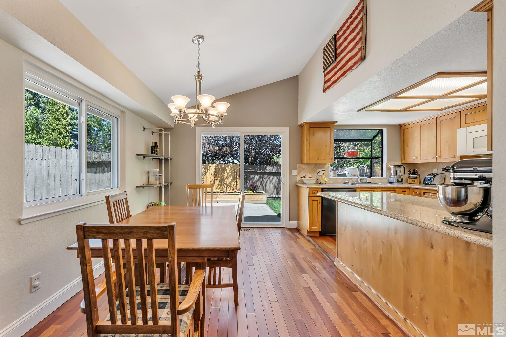 1802 Grand Point Way Reno, NV 89523 - Photo 4 of 19 a dining room with wooden floor a chandelier a wooden table and chairs