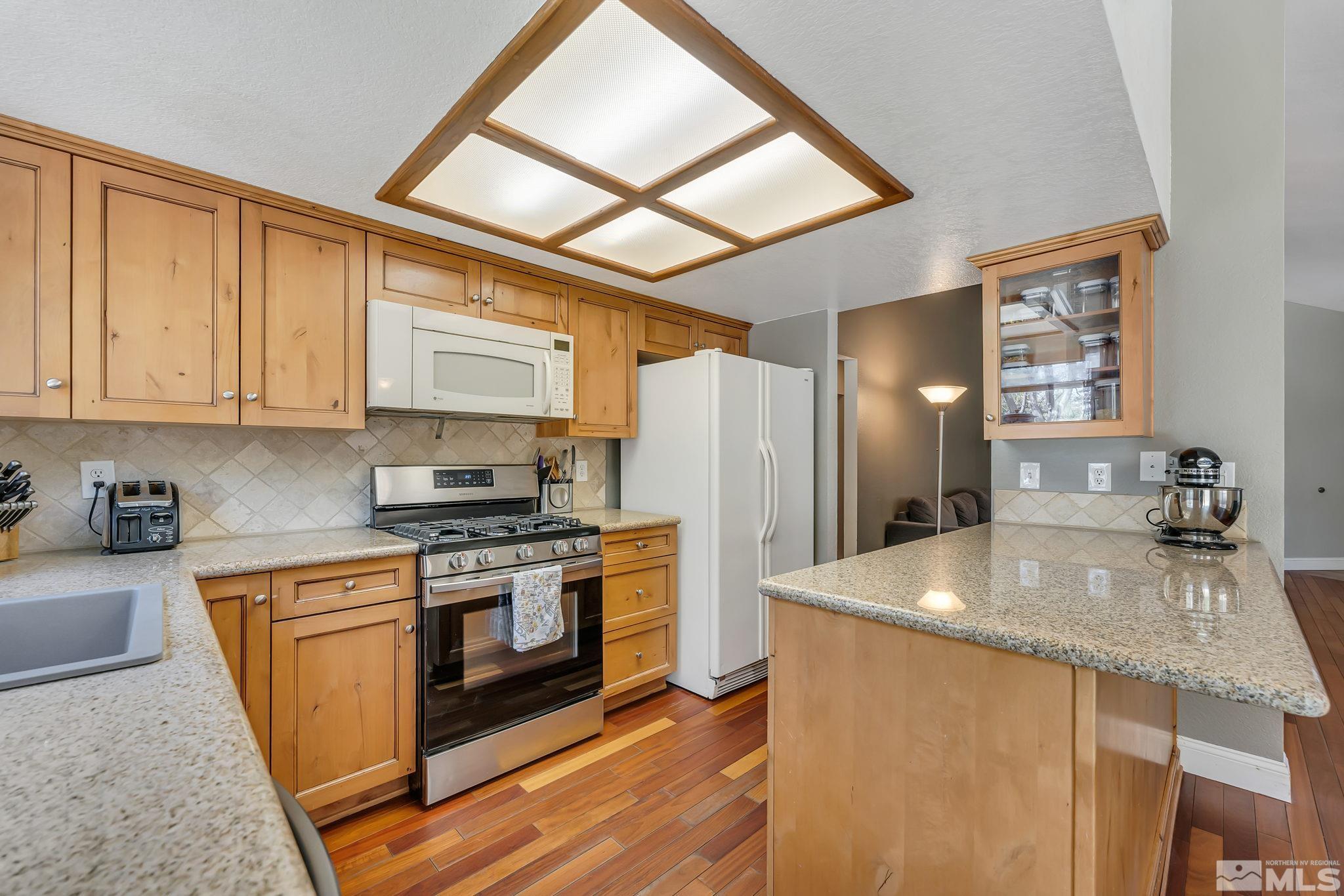 1802 Grand Point Way Reno, NV 89523 - Photo 6 of 19 a kitchen with stainless steel appliances granite countertop a refrigerator a stove and a sink with cabinets
