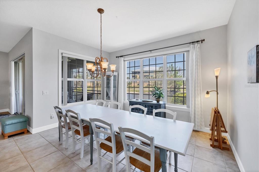 10720 Lemon Creek Loop, Unit 103 Englewood, FL 34224 - Photo 15 of 50 a view of a dining room with furniture large windows and wooden floor