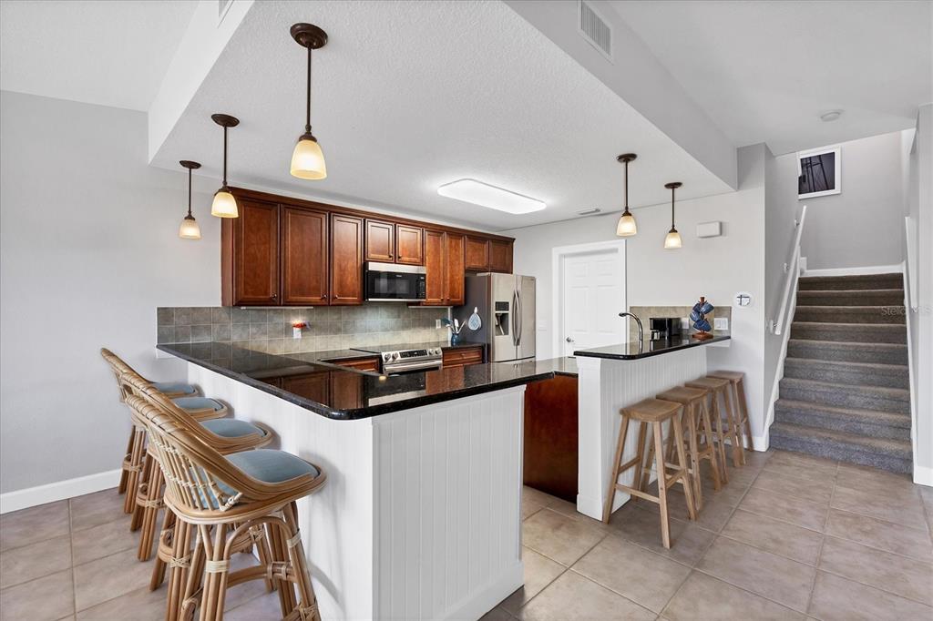 10720 Lemon Creek Loop, Unit 103 Englewood, FL 34224 - Photo 10 of 50 a kitchen with granite countertop wooden cabinets and stainless steel appliances