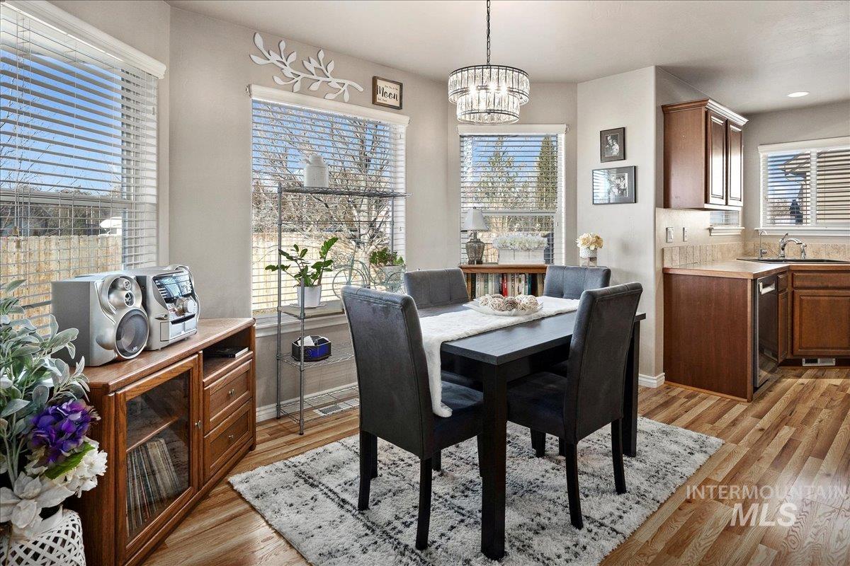 657 Creekside Way Twin Falls, ID 83301 - Photo 11 of 45 Dining area featuring light wood-style floors and a chandelier