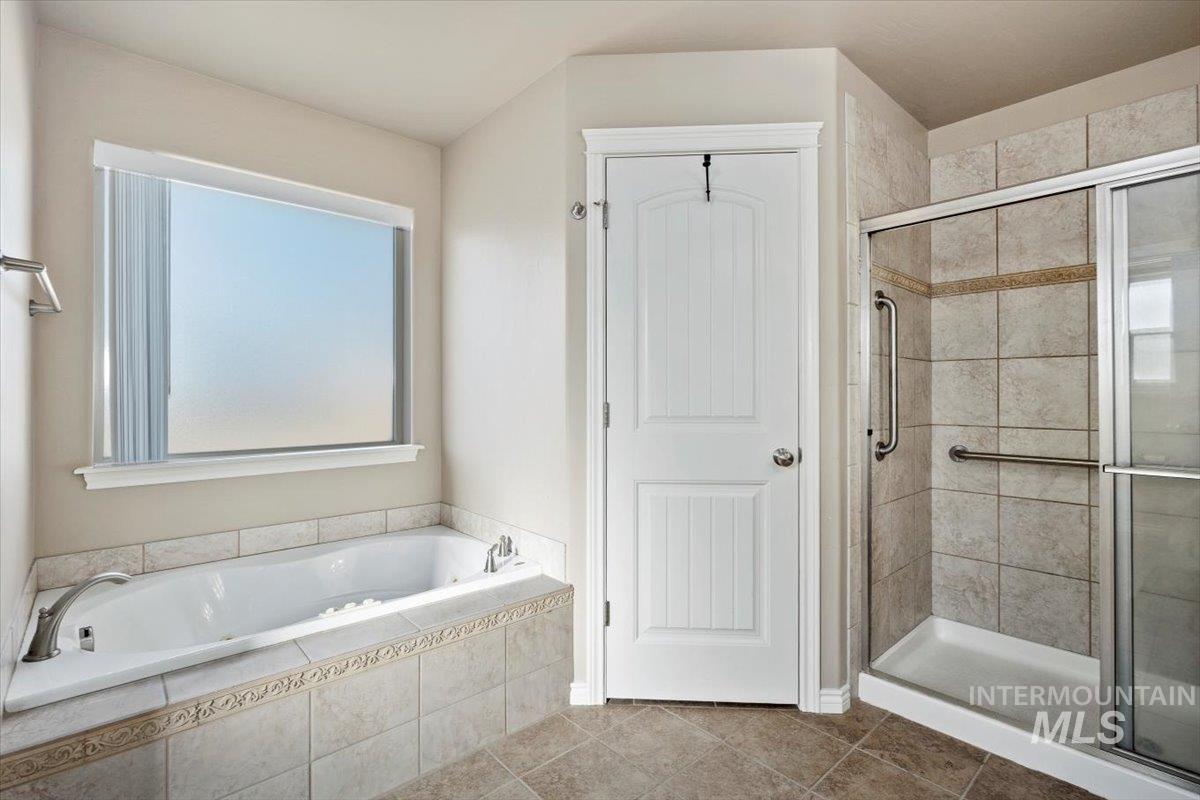 657 Creekside Way Twin Falls, ID 83301 - Photo 23 of 45 Full bath featuring a stall shower, a garden tub, and tile patterned flooring
