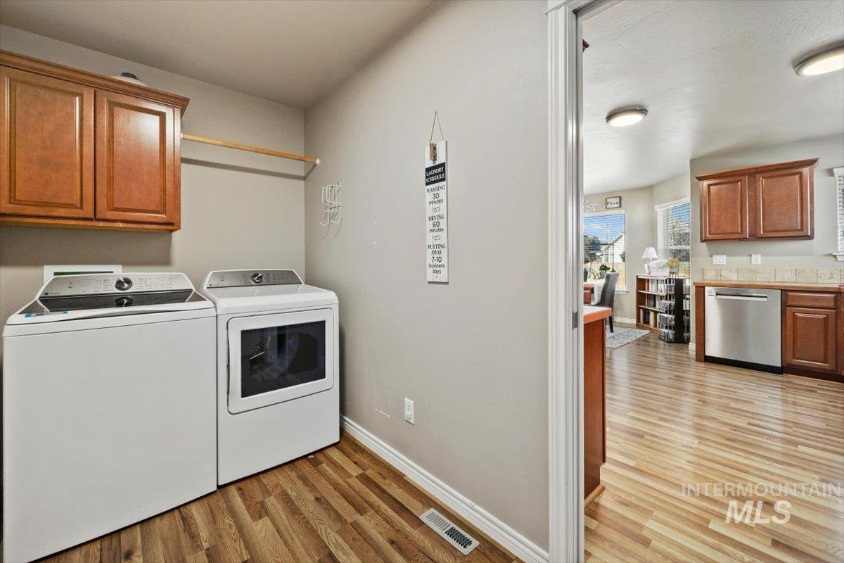 657 Creekside Way Twin Falls, ID 83301 - Photo 30 of 45 Washroom featuring light wood finished floors, cabinet space, and washing machine and dryer