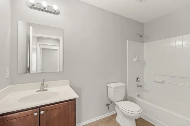 a bathroom with a sink toilet vanity and shower