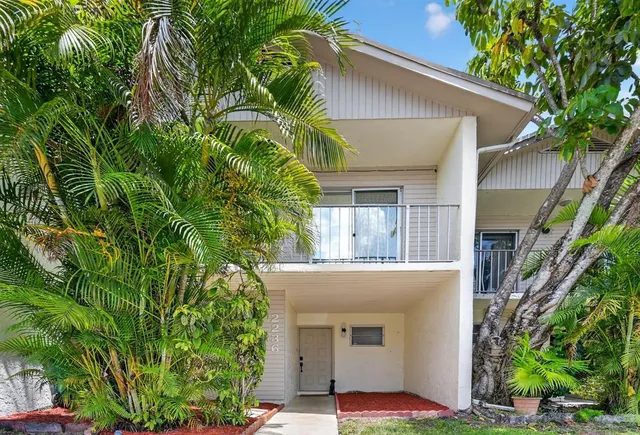 a front view of a house with plants