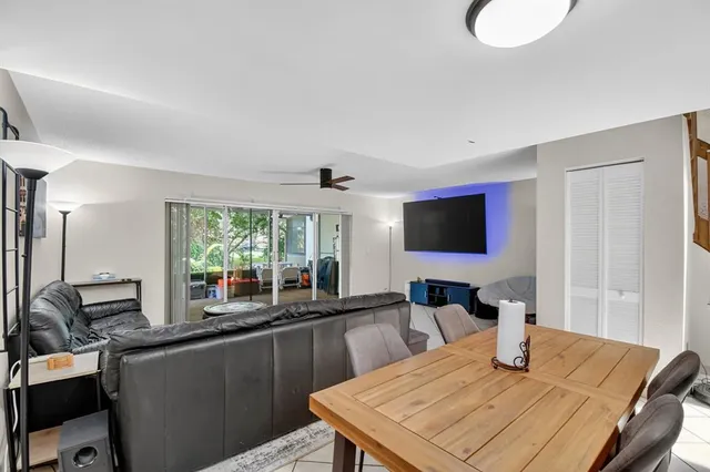 a kitchen with stainless steel appliances kitchen island granite countertop a table chairs and a refrigerator
