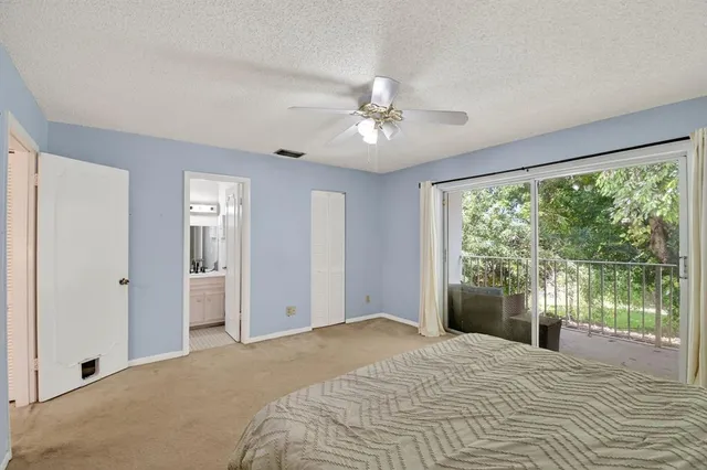 a bedroom with a large bed and a ceiling fan