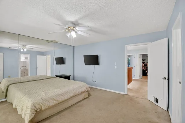a spacious bedroom with a large bed and a chandelier