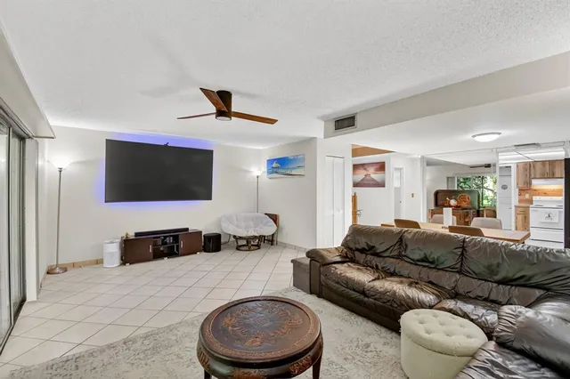 a living room with furniture and a ceiling fan