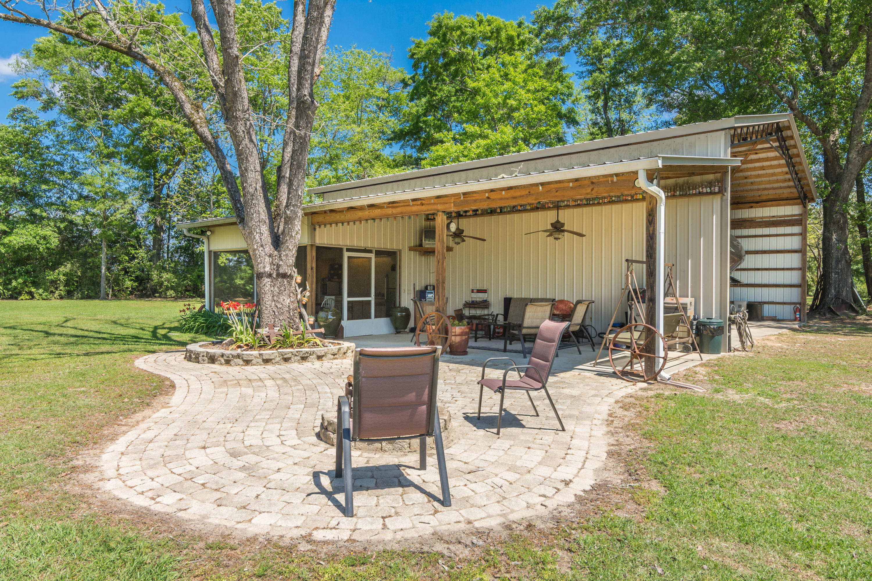 5995 Jack Stokes Road Baker, FL 32531 - Photo 15 of 60 a view of a patio with table and chairs under an umbrella