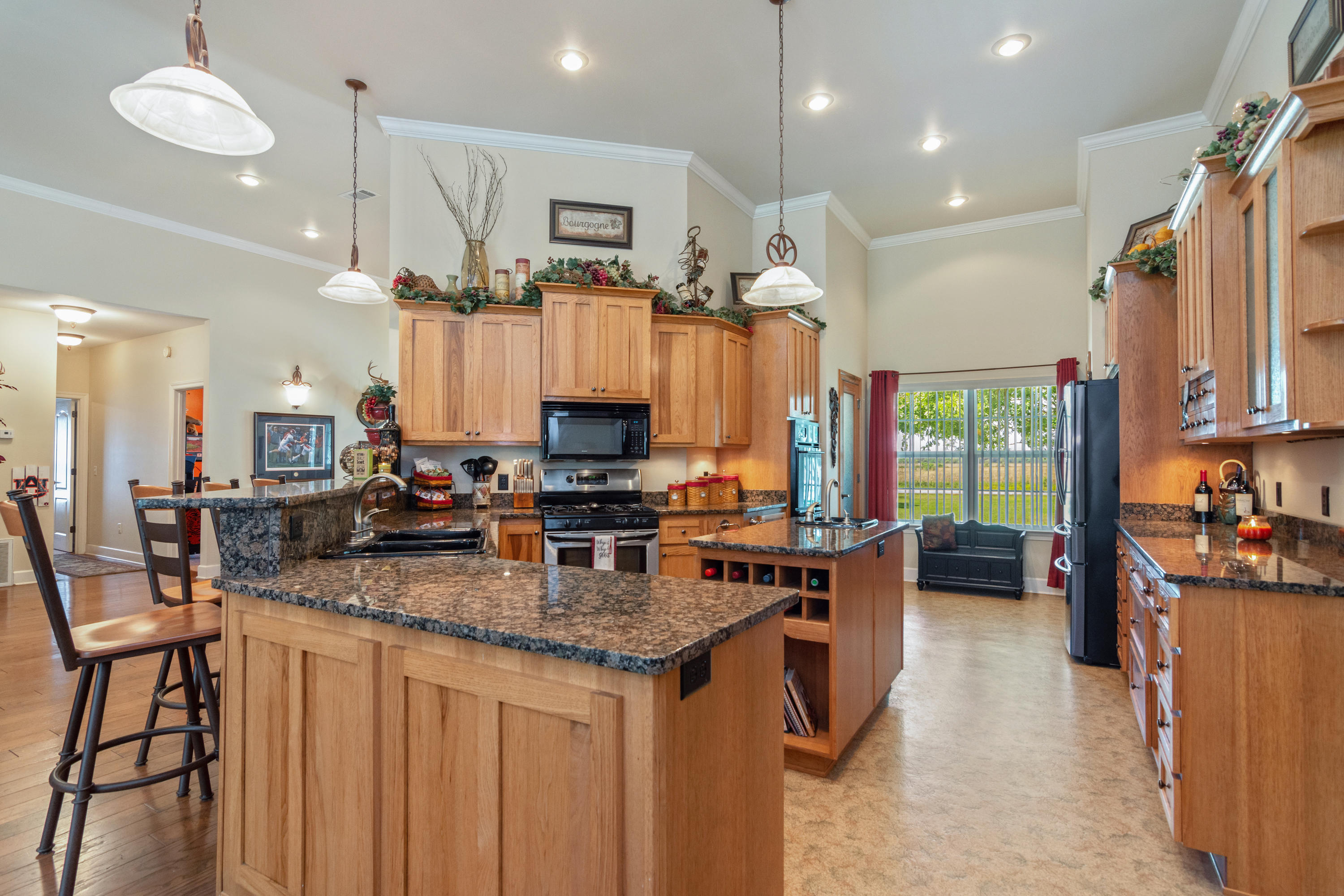 5995 Jack Stokes Road Baker, FL 32531 - Photo 28 of 60 a kitchen with kitchen island granite countertop a stove a sink a refrigerator and chairs