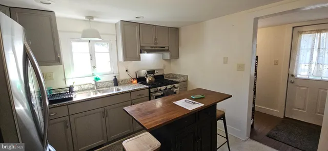 a kitchen with a refrigerator a stove a sink and cabinets