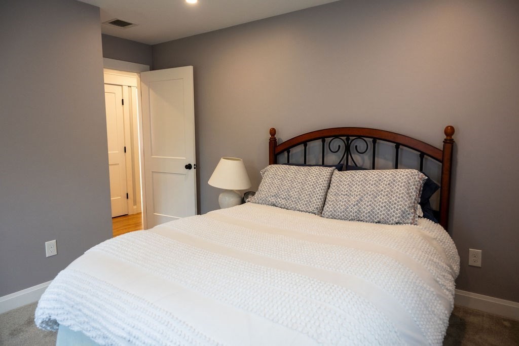 18 Belmore Road Natick, MA 01760 - Photo 29 of 30 a large bed sitting in a bedroom next to a bathroom