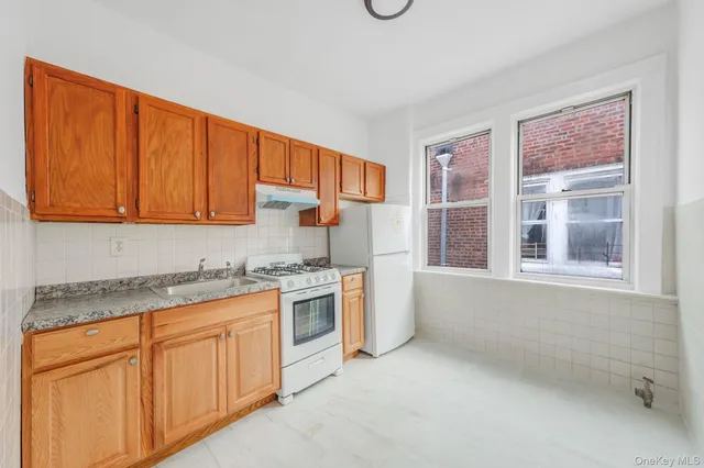 a kitchen with granite countertop cabinets stainless steel appliances a sink and a window