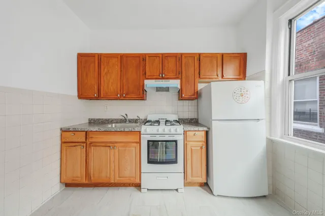 a kitchen with stainless steel appliances granite countertop a refrigerator and a stove