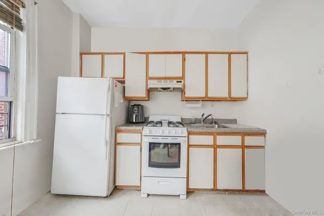 a white refrigerator freezer and a stove sitting inside of a kitchen