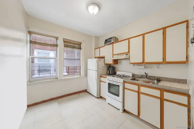 a kitchen with stainless steel appliances granite countertop a stove a sink and white cabinets