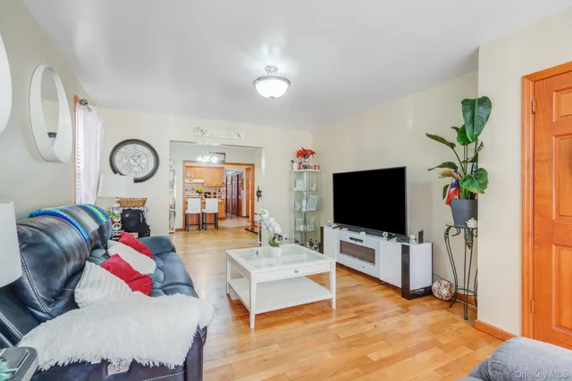 a living room with furniture a flat screen tv and a window