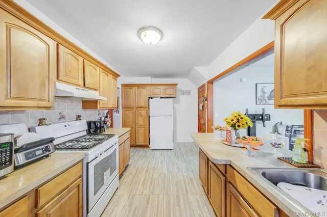 a kitchen with stainless steel appliances granite countertop a sink stove and refrigerator