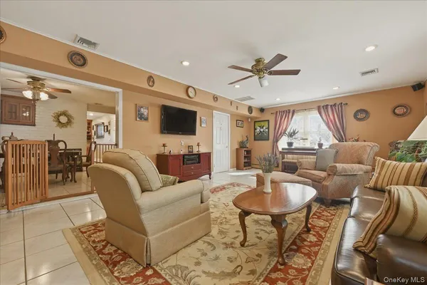 a living room with furniture a chandelier and a flat screen tv