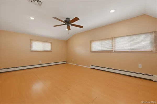 a view of a big room with wooden floor and windows