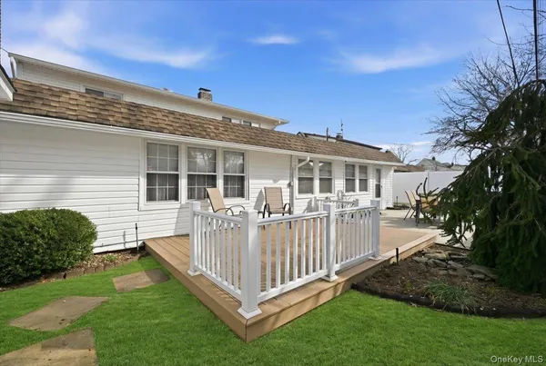 a view of a house with a wooden deck and a yard