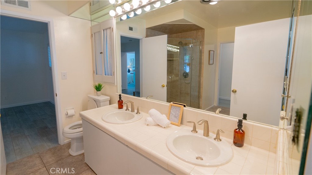 4669 Arriba Drive Tarzana, CA 91356 - Photo 18 of 22 a bathroom with a double vanity sink and a mirror