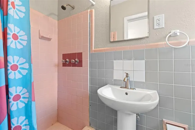 a bathroom with a sink a mirror and shower
